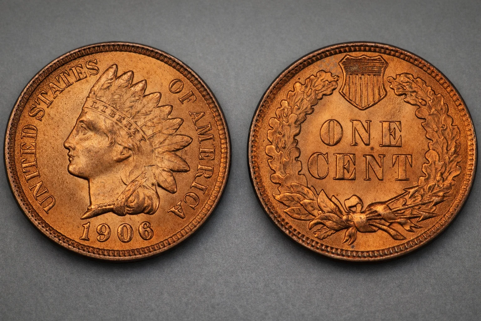 1906 Indian Head cent obverse and reverse on neutral gray surface.